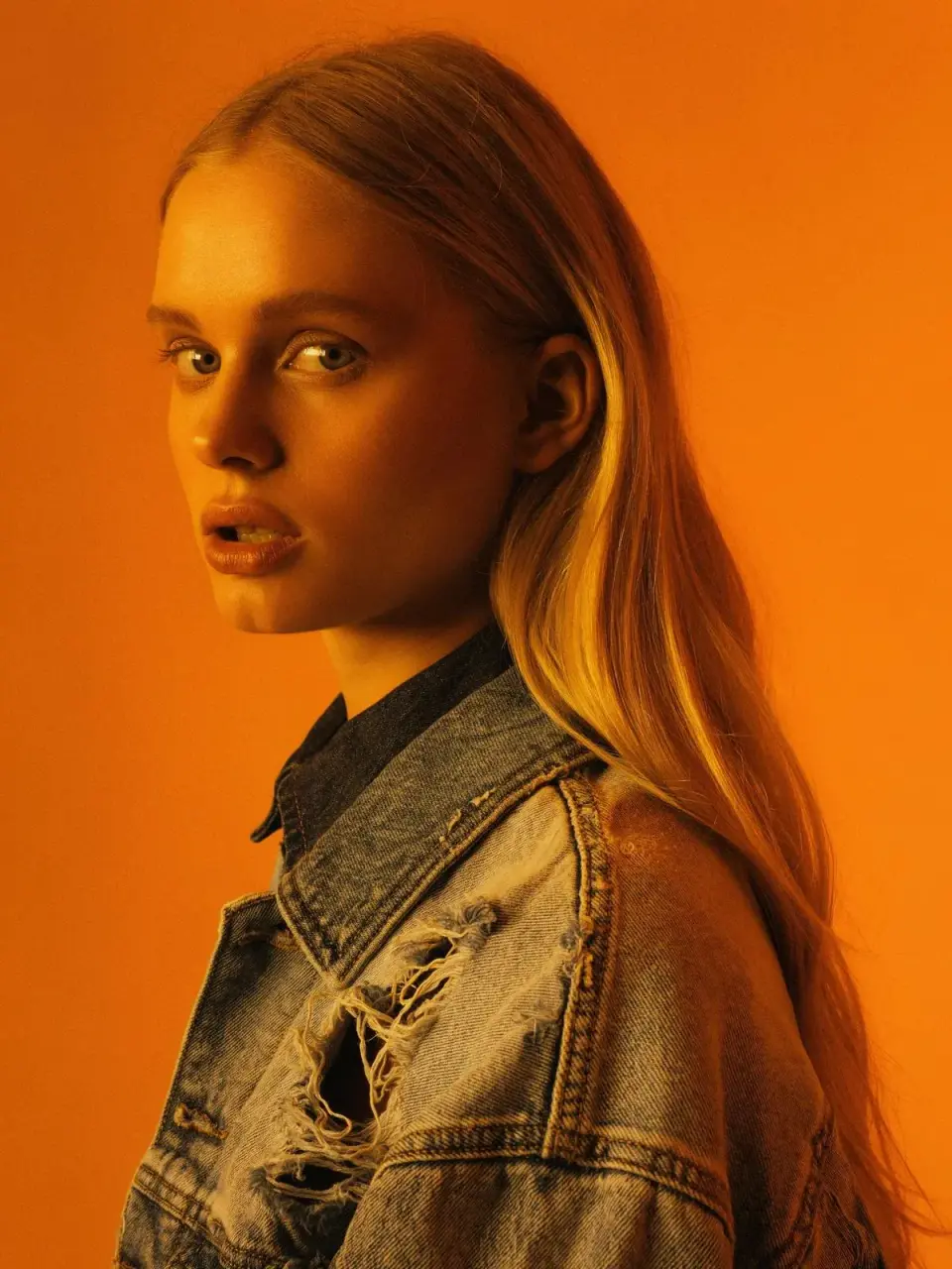 FLUX 3 Image Klein — Portrait of a woman in a denim jacket against orange